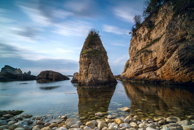 Rock formations in sea against sky