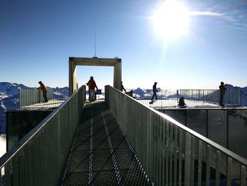 People enjoying mountain view at observation point against sky