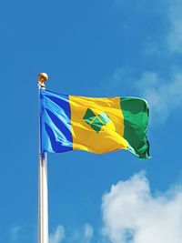 Low angle view of saint vincent and the grenadines flag against sky