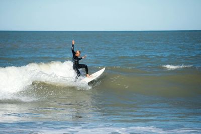 Side view of female surfer surfing in sea