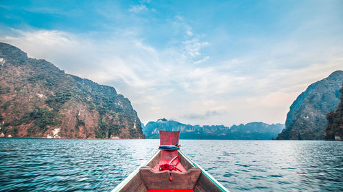 Scenic view of sea by mountains against sky