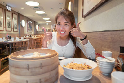 Portrait of smiling young woman sitting at restaurant