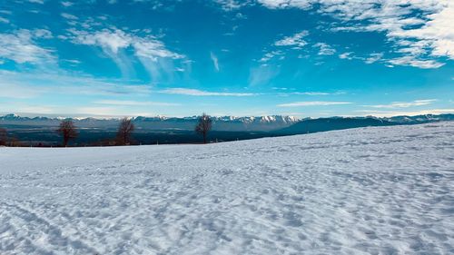 Scenic view of snowcapped field against sky