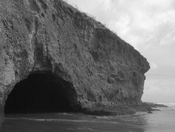 Rock formations by sea against sky