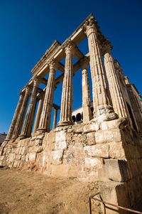 Low angle view of old temple against clear blue sky