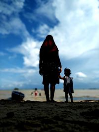 Rear view of people standing on beach