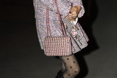 Low section of woman standing against wall