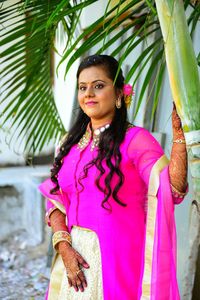 Portrait of smiling woman standing against pink tree