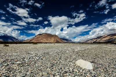 Surface level of land against cloudy sky