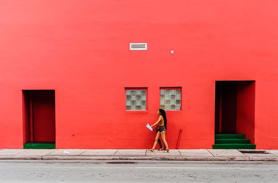 Woman standing with red umbrella