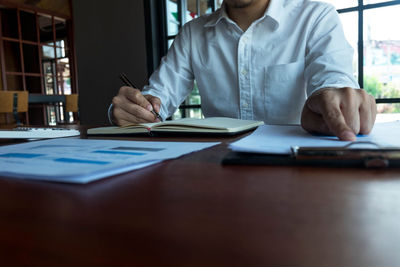 Midsection of man sitting on table