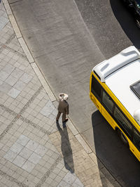 High angle view of man standing on sidewalk in city