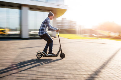 Side view of man riding motorcycle on street in city