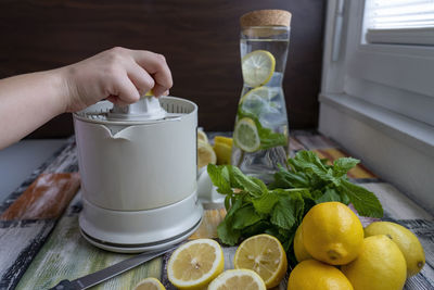 Preparation of fresh juices press on fresh lemon and lime. lemon squeezer machine or lemon presser.