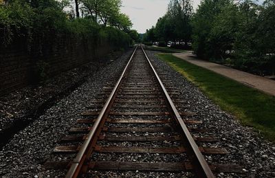 Railway tracks amidst trees against sky