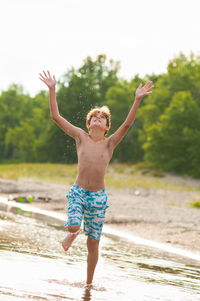 Full length of shirtless boy on beach