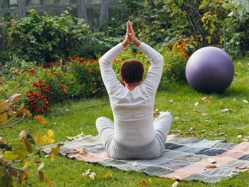 An elderly woman practices yoga in the fresh air.