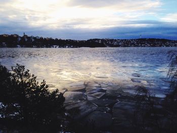 Scenic view of lake against cloudy sky