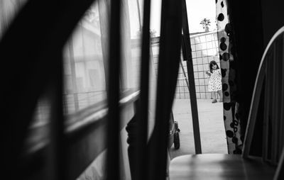 Playful girl seen through doorway