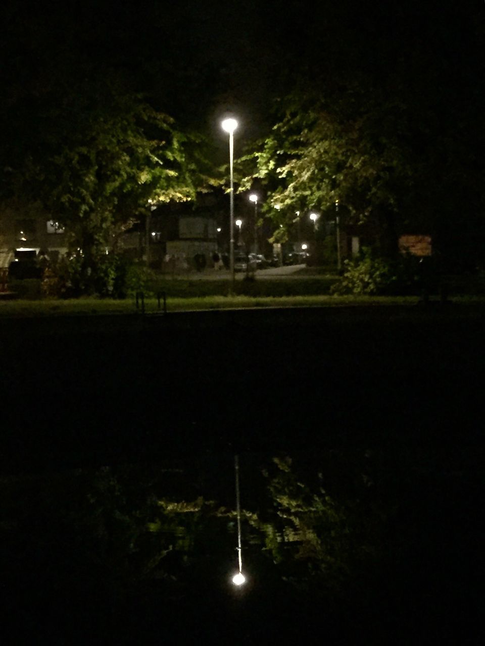 EMPTY ROAD ALONG ILLUMINATED STREET LIGHTS