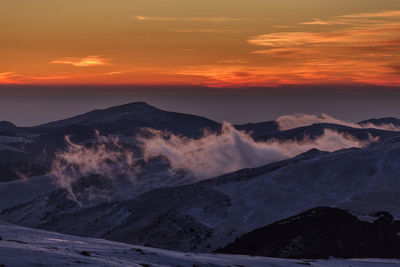 Scenic view of snowcapped mountains against sky during sunset