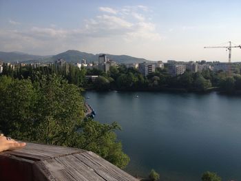 Scenic view of lake by city against sky
