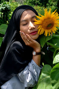 Beautiful young woman with yellow flower