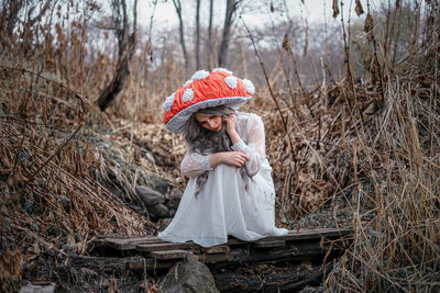 Full length of woman wearing hat against trees in forest