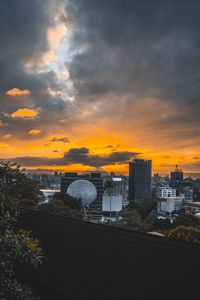 Buildings in city against sky during sunset