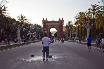 Rear view of people walking in front of historical building