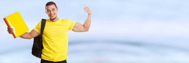 Midsection of man standing on yellow umbrella against sky