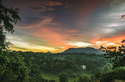 Scenic view of landscape against dramatic sky during sunset