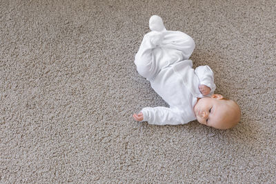 High angle view of baby girl lying on floor