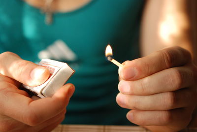 Close-up of hands holding candles