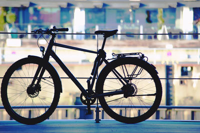 Close-up of bicycle wheel against illuminated city