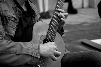 Midsection of man playing guitar