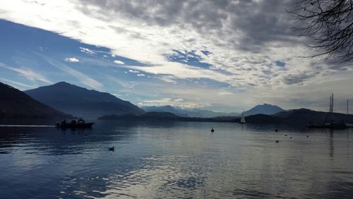 Scenic view of lake and mountains against cloudy sky