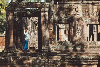 Rear view full length of woman standing outside temple