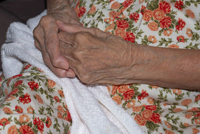 Close-up of hands on bed