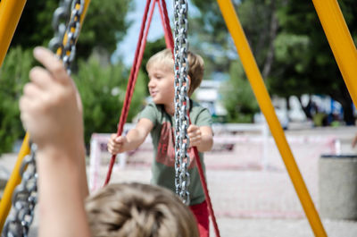 Children playing on swing at playground
