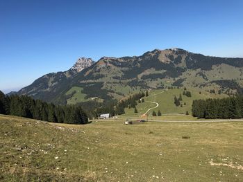 Scenic view of landscape and mountains against clear blue sky