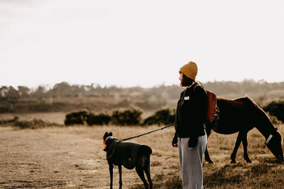 Woman with dog standing of field