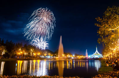 Firework display over river at night