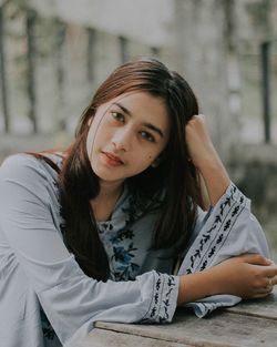 Portrait of young woman sitting outdoors