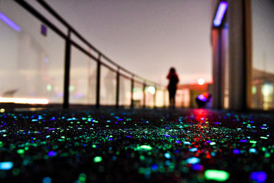 Person standing in illuminated city against sky at night