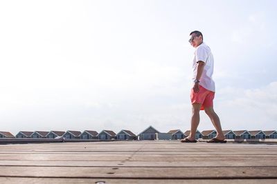 Full length of young man standing against sky