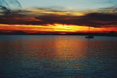 Scenic view of sea against dramatic sky during sunset