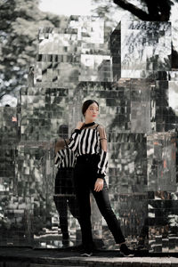 Full length of woman standing against glass structure