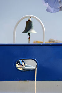 Bell in boat against sky