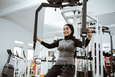 Portrait of young woman exercising in gym